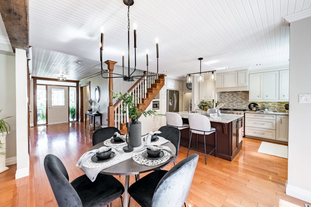 An interior real estate photo of a staged kitchen and dining area