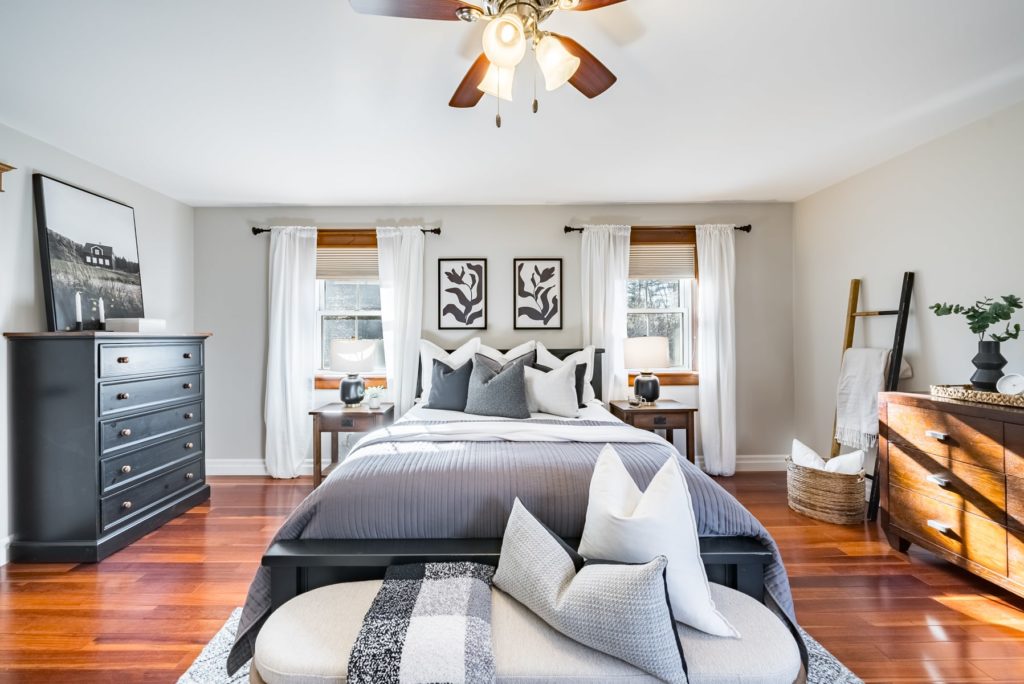 An interior real estate photo of a staged bedroom showing a bed